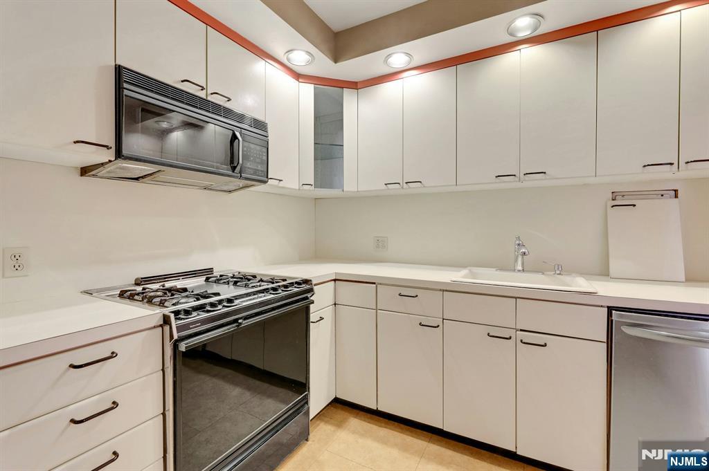 5 Horizon Road, Unit 907 Fort Lee, NJ 07024 - Photo 17 of 48 a kitchen with white cabinets and appliances
