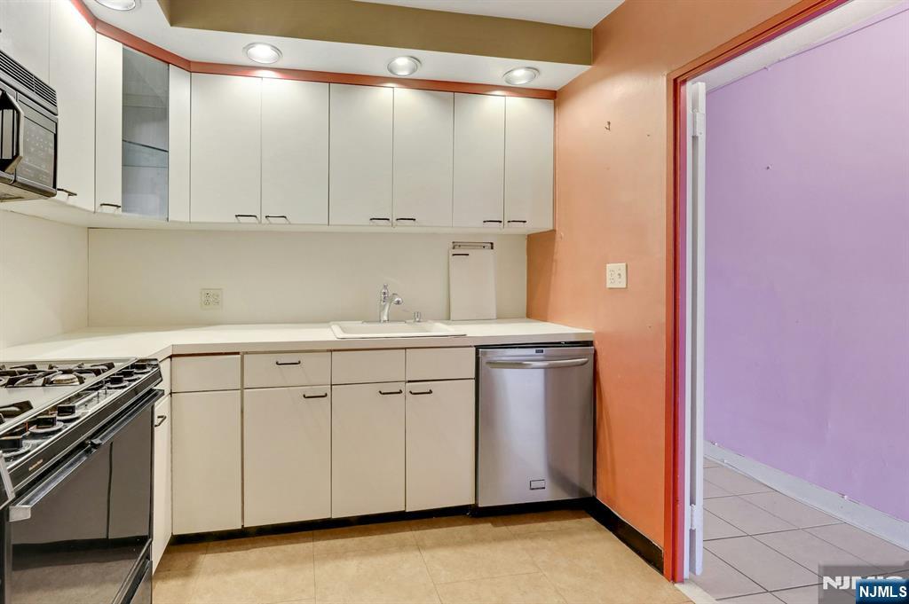5 Horizon Road, Unit 907 Fort Lee, NJ 07024 - Photo 18 of 48 a kitchen with white cabinets and white appliances