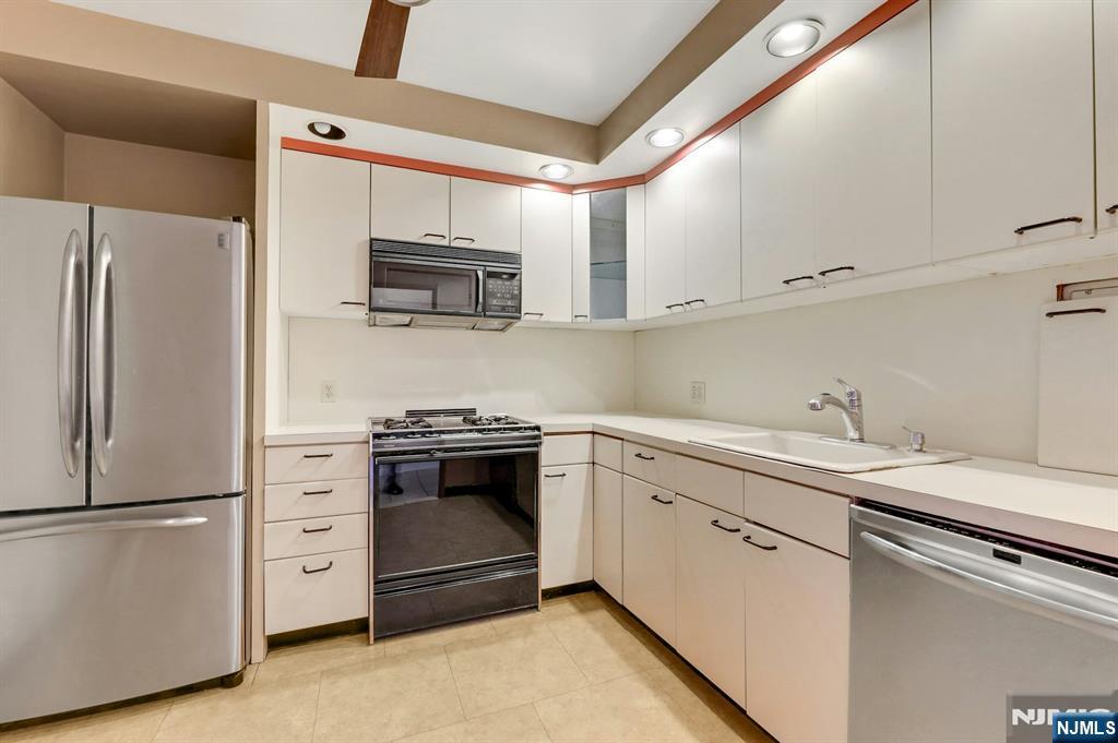 5 Horizon Road, Unit 907 Fort Lee, NJ 07024 - Photo 20 of 48 a kitchen with stainless steel appliances white cabinets and a refrigerator