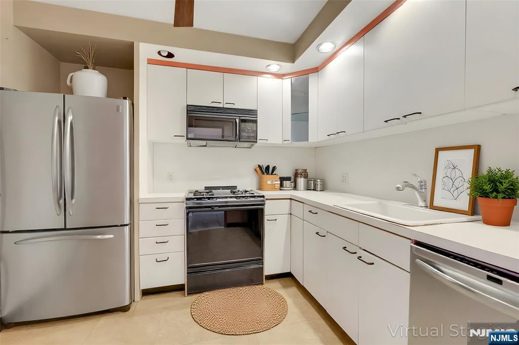5 Horizon Road, Unit 907 Fort Lee, NJ 07024 - Photo 7 of 48 a kitchen with stainless steel appliances a refrigerator sink and microwave