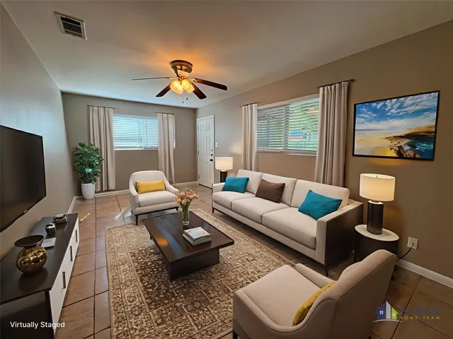 a living room with furniture a flat screen tv and a window