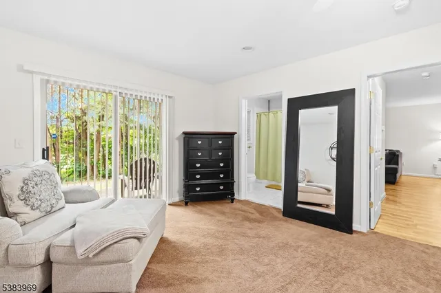 a living room with furniture and a dresser with a large window