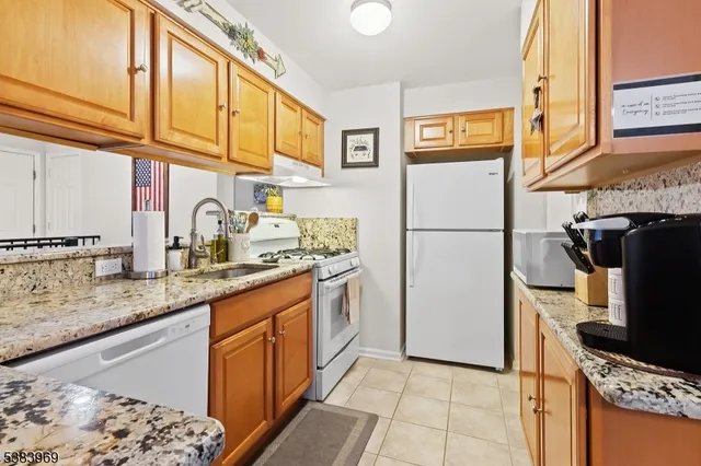 a kitchen with stainless steel appliances granite countertop a refrigerator a stove and a sink