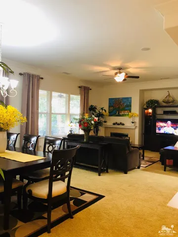 a living room with furniture kitchen view and a large window