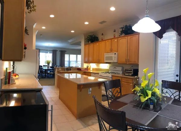 a kitchen with kitchen island granite countertop lots of counter top space and cabinets