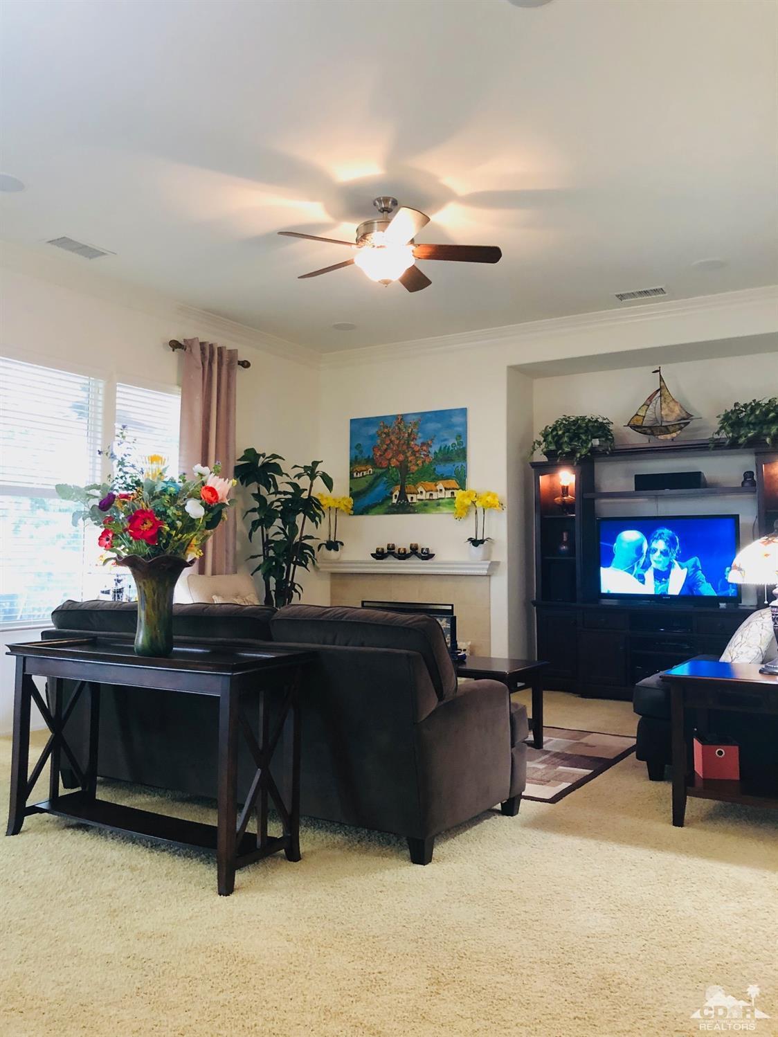 49535 Redford Way Indio, CA 92201 - Photo 10 of 28 a living room with furniture a fireplace and a chandelier