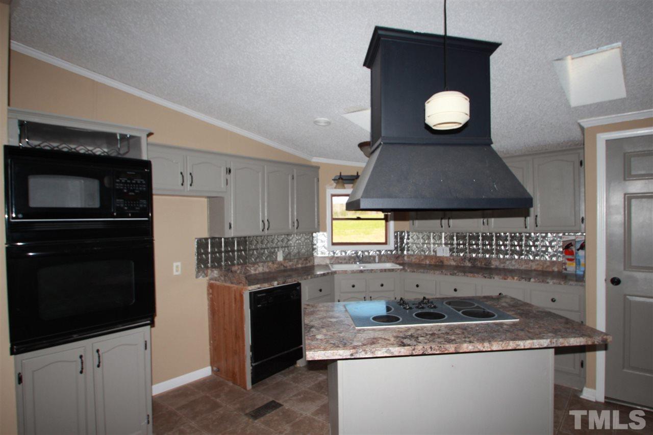 290 Hal Melton Road Roxboro, NC 27574 - Photo 3 of 14 a kitchen with a sink a stove and cabinets