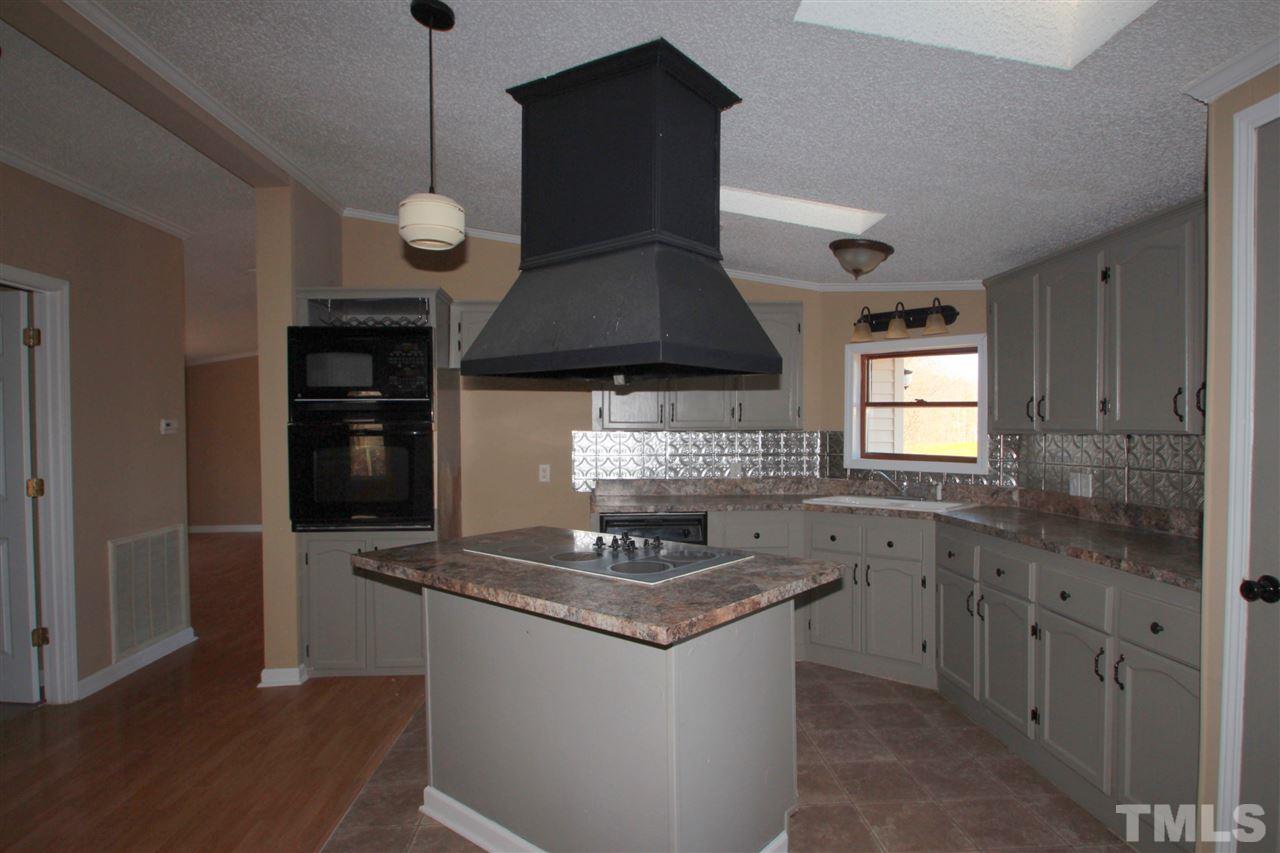290 Hal Melton Road Roxboro, NC 27574 - Photo 4 of 14 a kitchen with stainless steel appliances granite countertop a stove a sink and a refrigerator