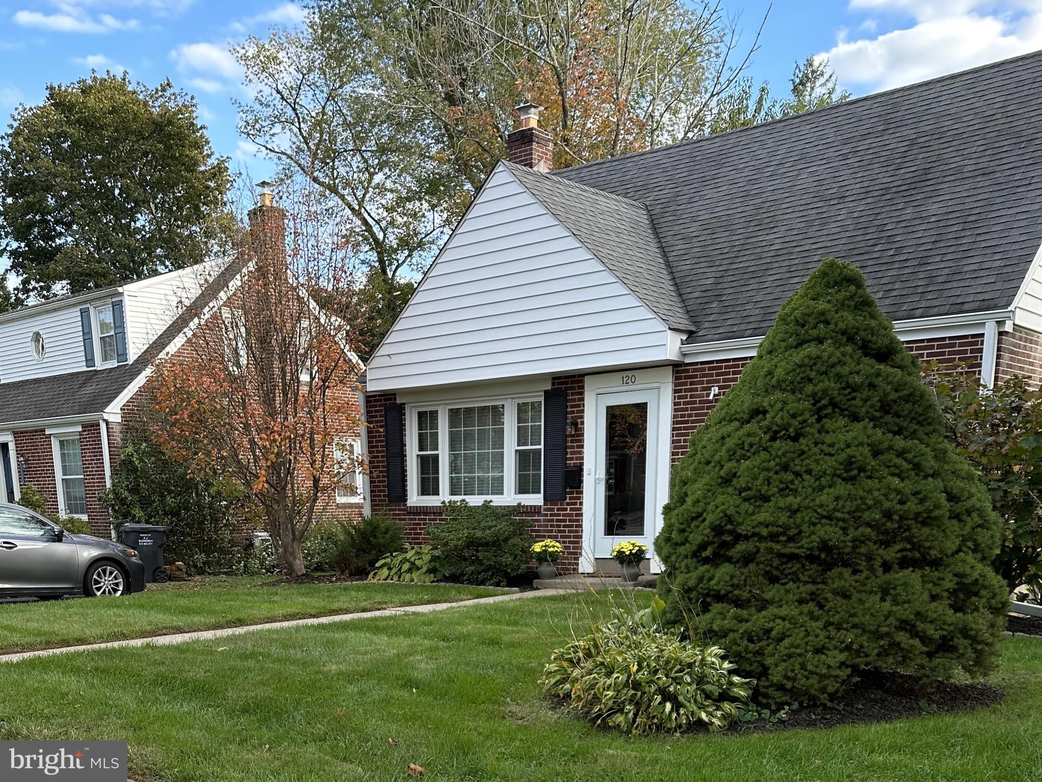 120 Richmond Road Paoli, PA 19301 - Photo 2 of 15 a front view of a house with a garden and trees