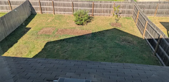 a view of a yard in front of a house with a large window