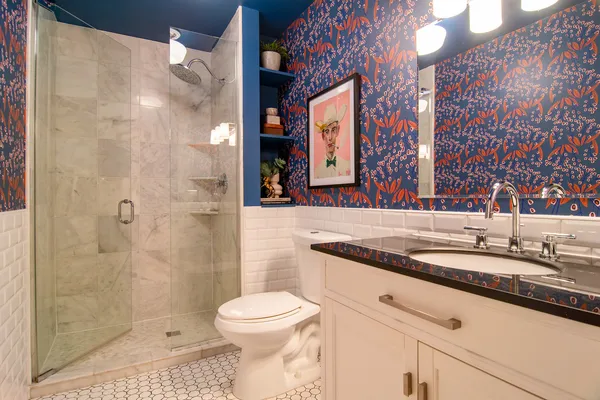 a bathroom with a granite countertop sink a toilet and shower
