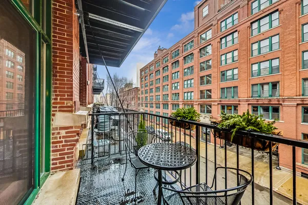 a view of a balcony with a table and chairs and wooden fence