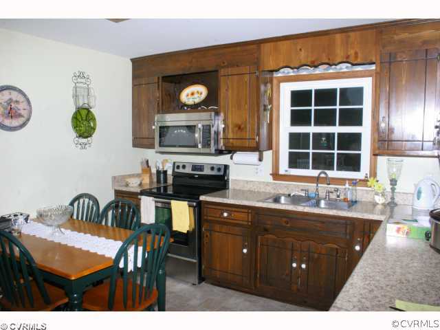 15018 Harrowgate Road Chester, VA 23831 - Photo 8 of 12 a kitchen with a dining table and chairs