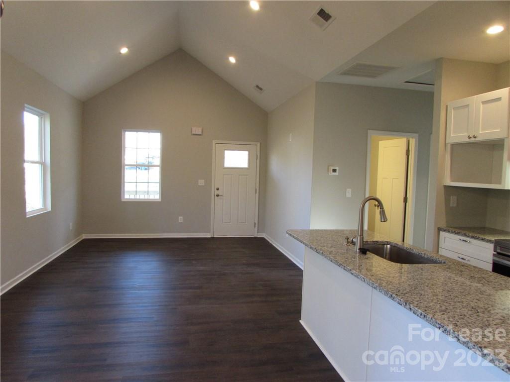 504 Messner Street, Unit 5 Salisbury, NC 28144 - Photo 5 of 11 a kitchen with granite countertop white cabinets and wooden floor