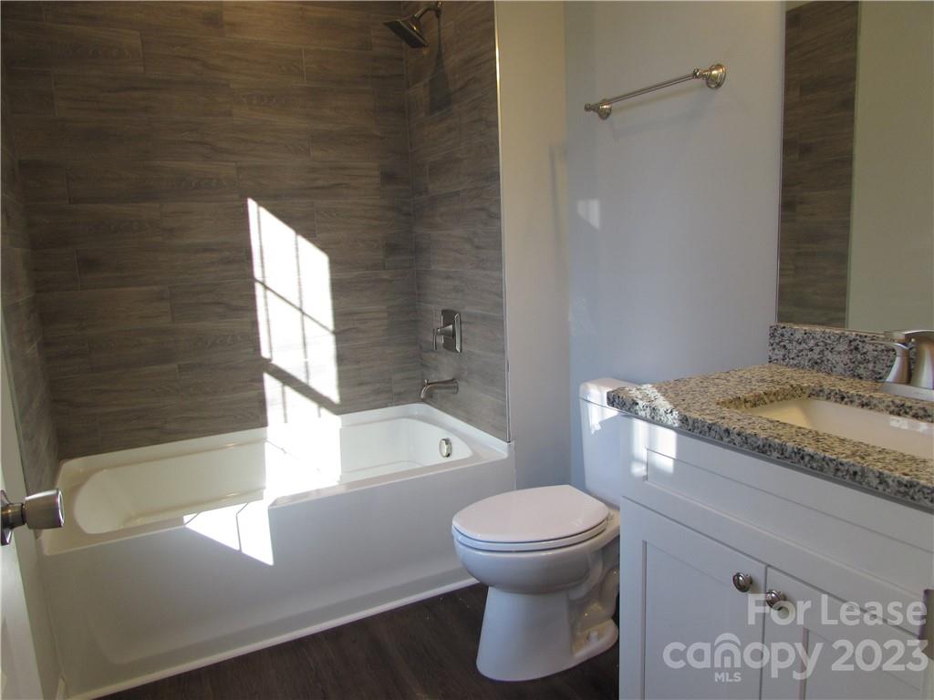 504 Messner Street, Unit 5 Salisbury, NC 28144 - Photo 7 of 11 a bathroom with a granite countertop toilet and a sink
