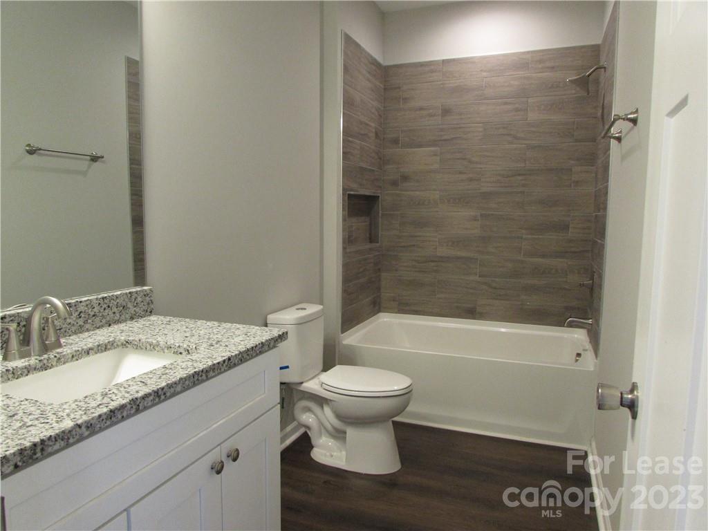504 Messner Street, Unit 5 Salisbury, NC 28144 - Photo 10 of 11 a bathroom with a granite countertop toilet a sink and bathtub