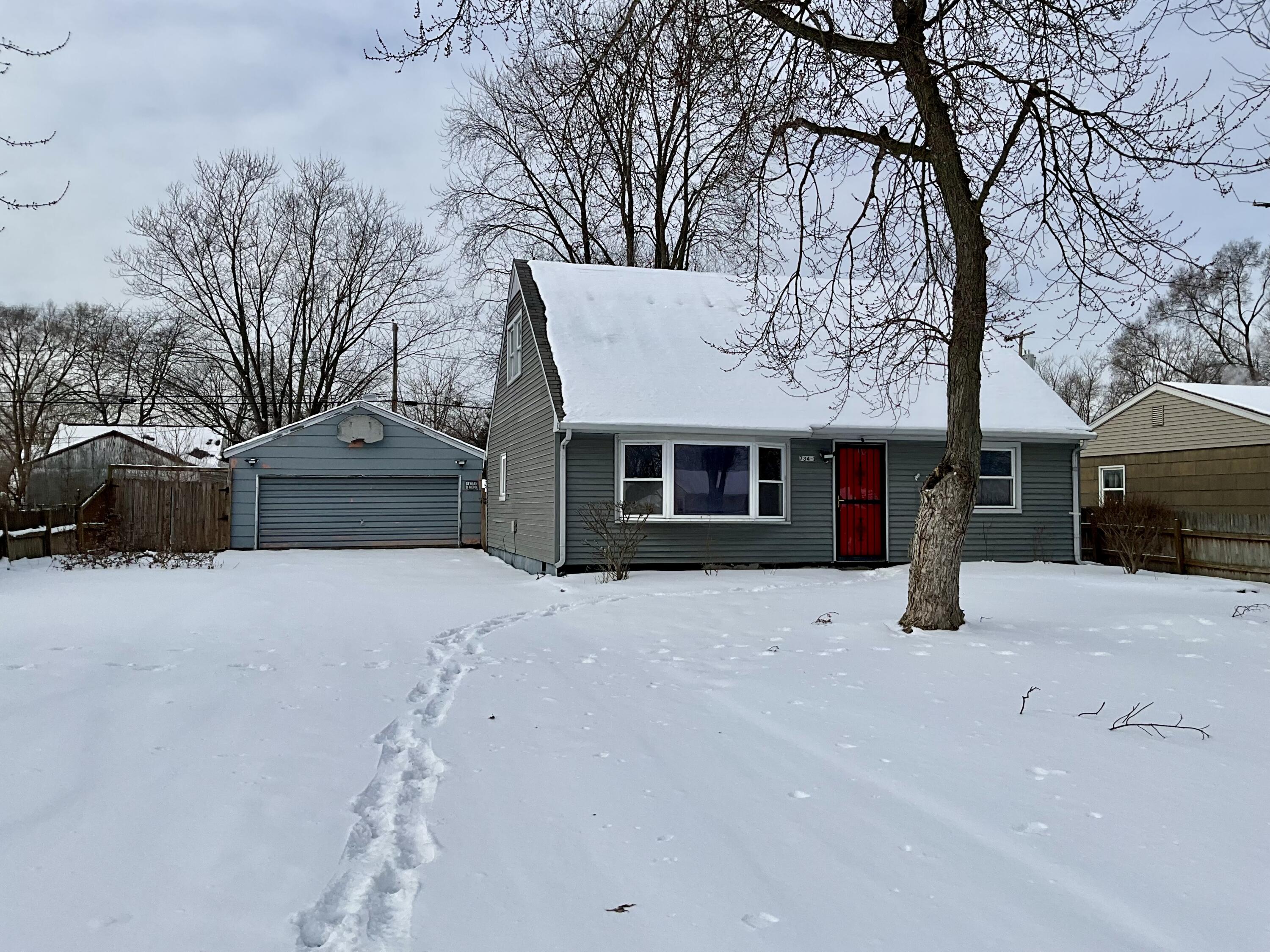 a front view of a house with a yard covered with snow in front of house
