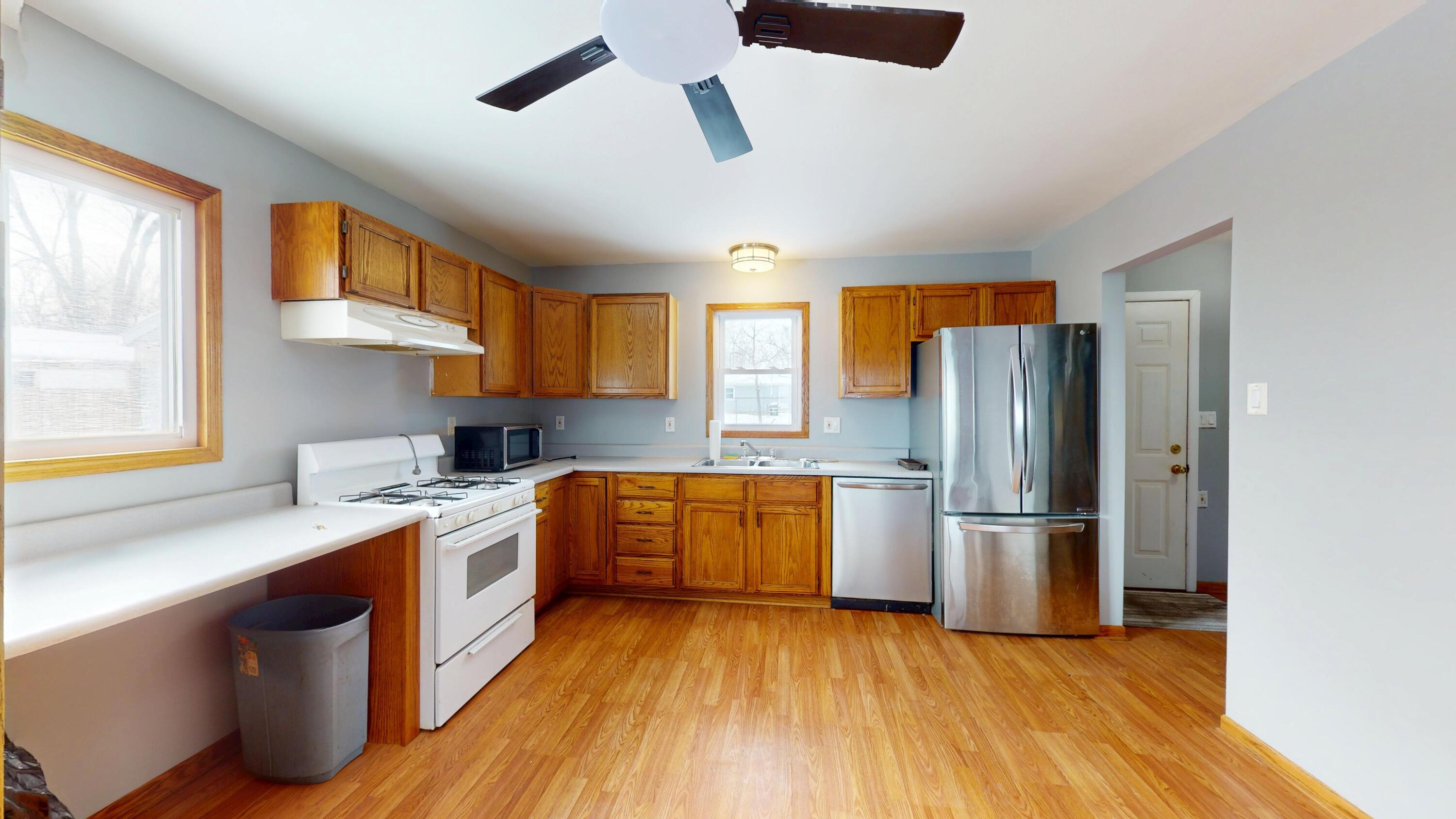 734-1 Juniper Road Valparaiso, IN 46385 - Photo 8 of 34 a kitchen with stainless steel appliances granite countertop a refrigerator a sink dishwasher a stove and white countertops with wooden floor