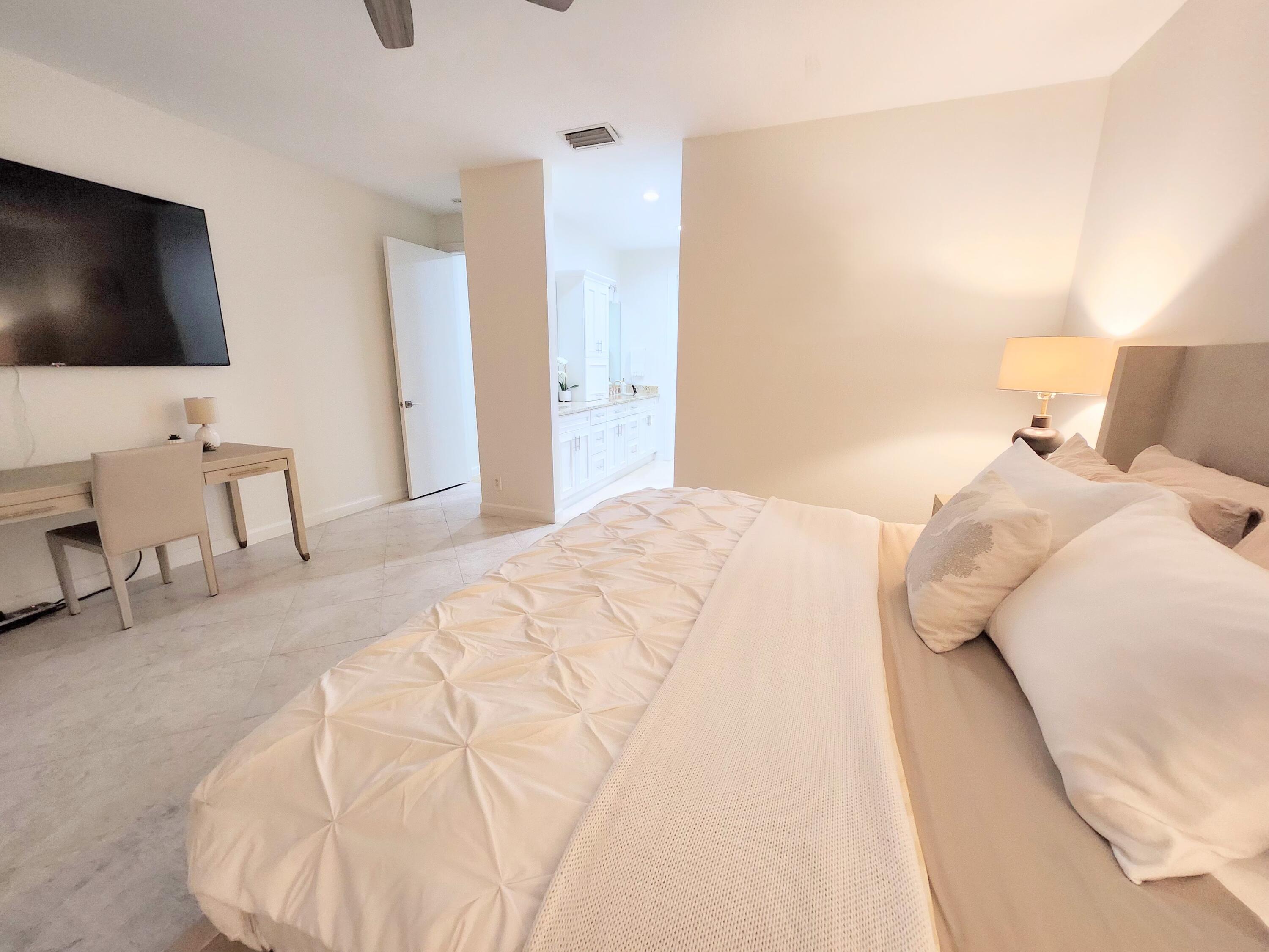 3567 Commodore Circle Delray Beach, FL 33483 - Photo 26 of 76 a bedroom with a bed and a flat screen tv