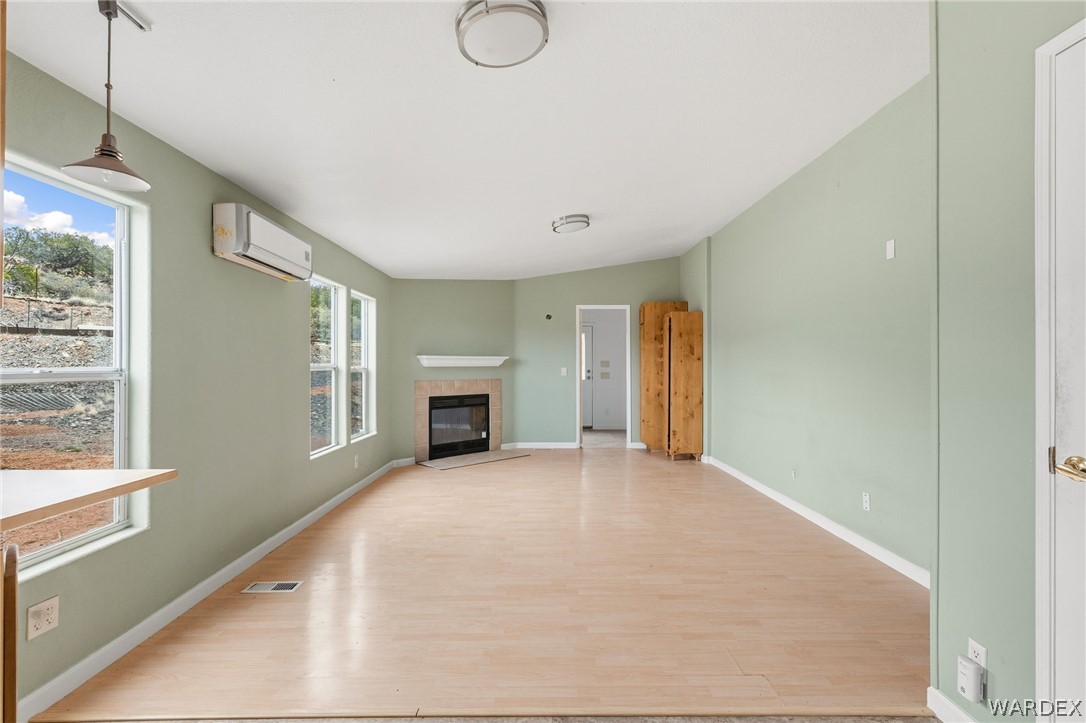3894 North Lookout Canyon Road Kingman, AZ 86401 - Photo 15 of 64 Unfurnished living room with wood finished floors, vaulted ceiling, and a fireplace