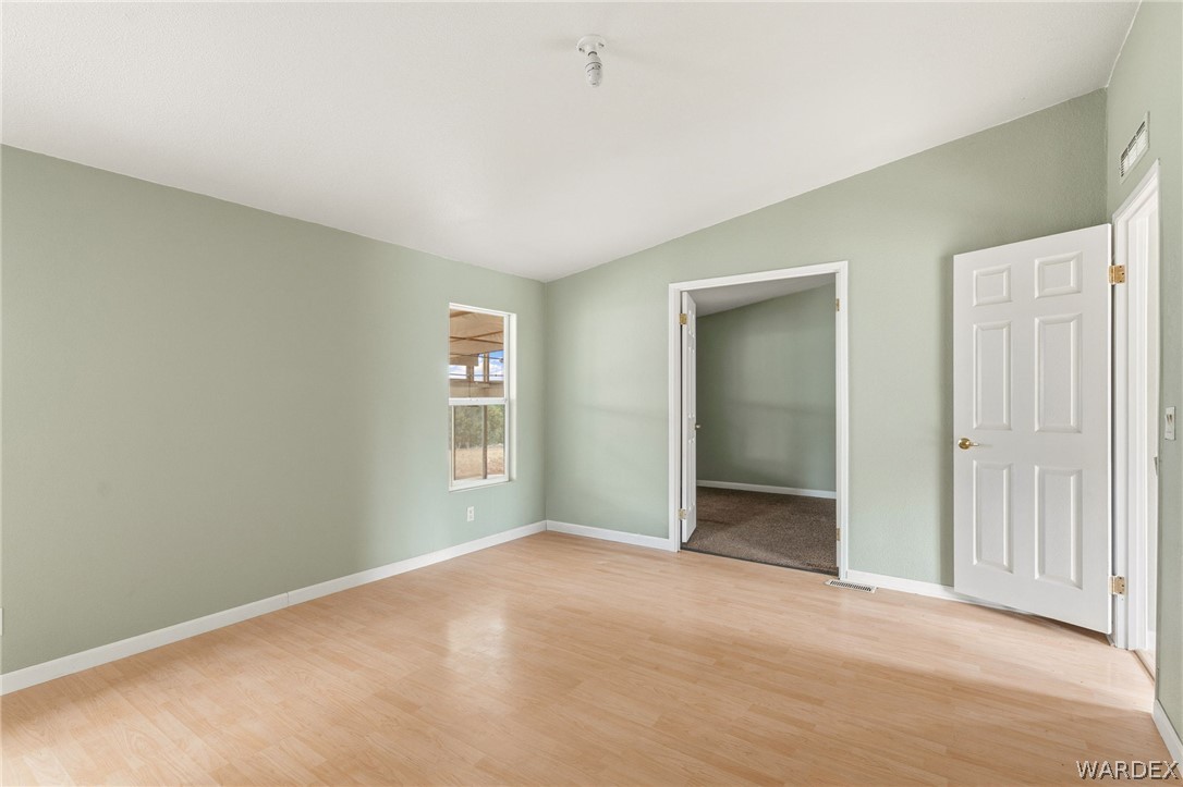 3894 North Lookout Canyon Road Kingman, AZ 86401 - Photo 18 of 64 Unfurnished bedroom with vaulted ceiling, light wood finished floors, and a spacious closet
