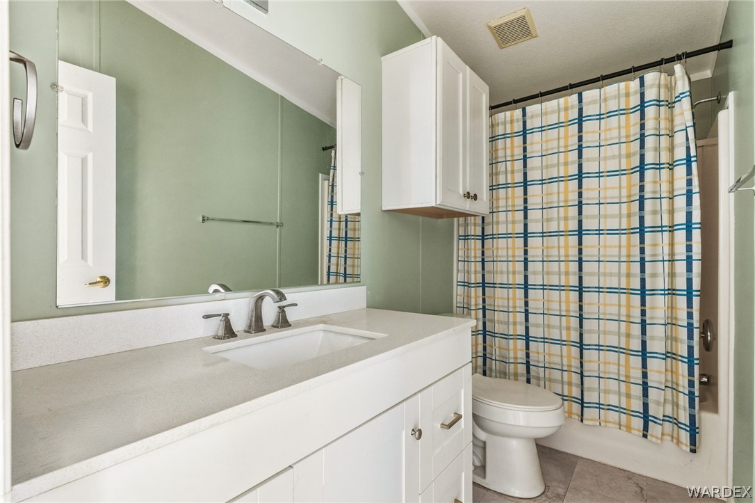 3894 North Lookout Canyon Road Kingman, AZ 86401 - Photo 24 of 64 Bathroom with shower / tub combo with curtain, vanity, and light tile patterned floors