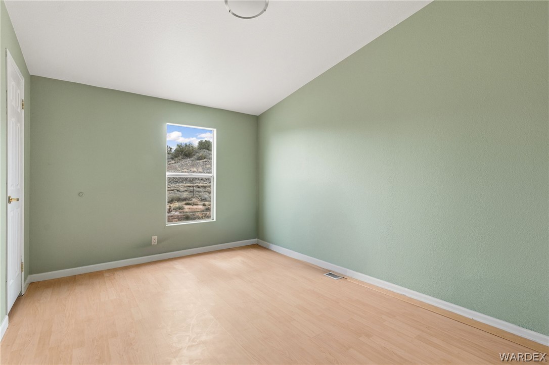3894 North Lookout Canyon Road Kingman, AZ 86401 - Photo 26 of 64 Unfurnished room with wood finished floors and vaulted ceiling