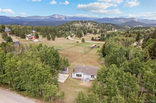 an aerial view of residential houses with outdoor space and trees