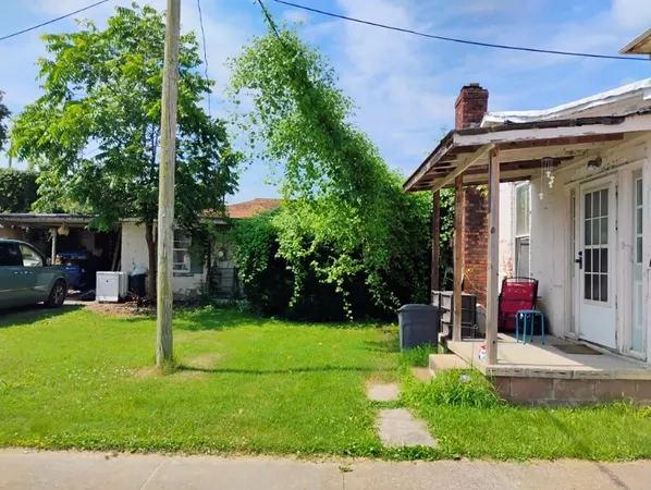 a view of a house with backyard sitting area and garden