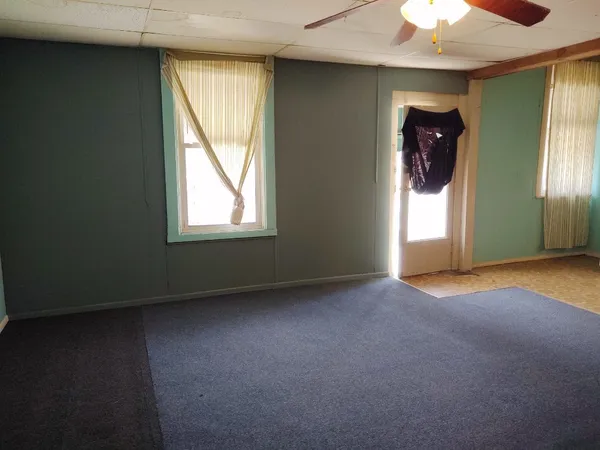 an empty room with windows and closet