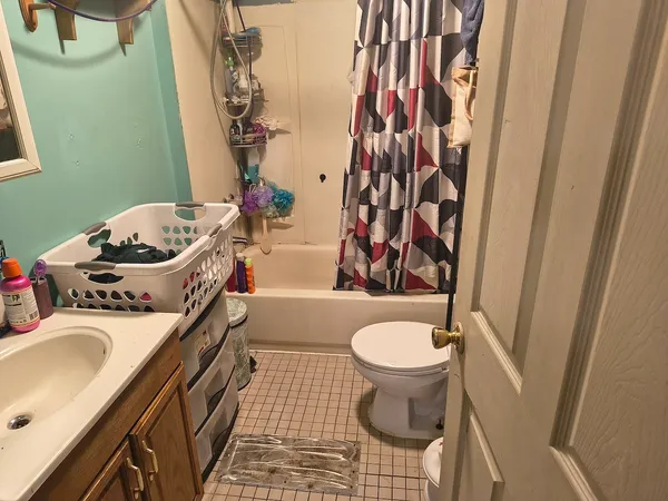 a bathroom with a sink toilet and shower curtain
