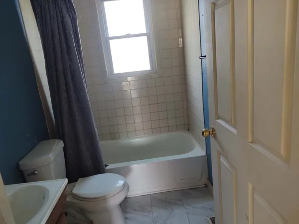 a white bath tub sitting next to a white toilet