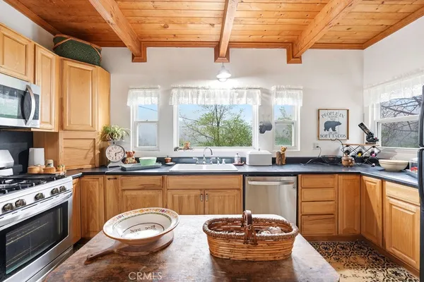 a kitchen with a stove a sink and a wooden cabinets