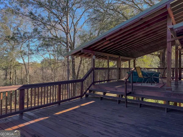 a view of a deck with couches with wooden floor and fence