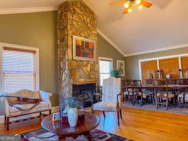 a living room with fireplace furniture and a large window
