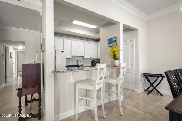 a kitchen with a refrigerator and a dining table