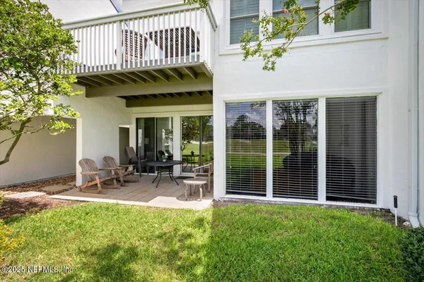 a view of a chair and table in backyard of the house