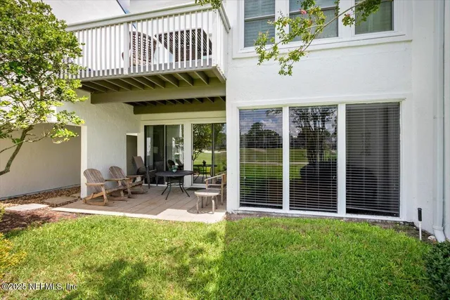a view of a chair and table in backyard of the house