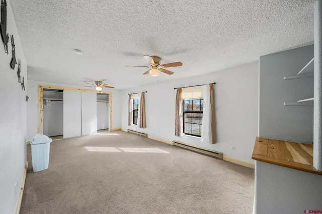 a view of a livingroom with a ceiling fan and window