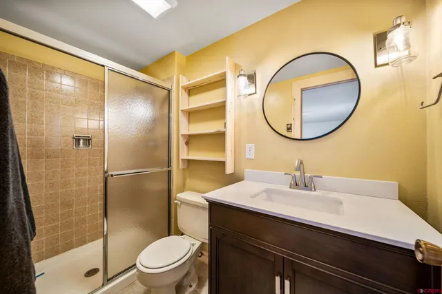 a bathroom with a sink a toilet and a mirror