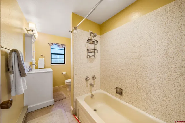 a bathroom with a bathtub a window and a shower