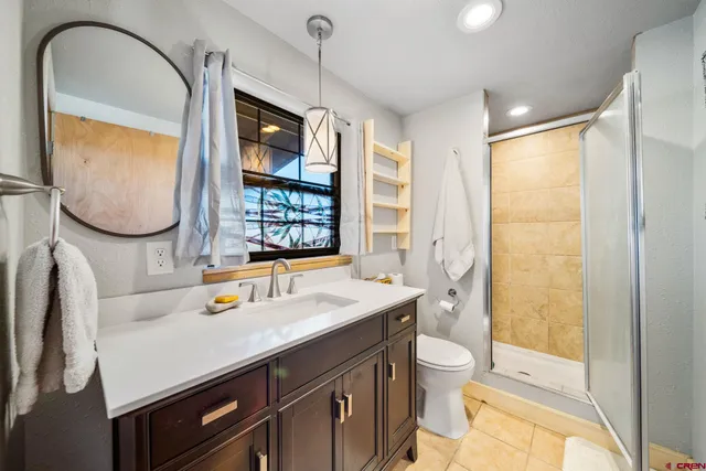 a bathroom with a sink a toilet and shower