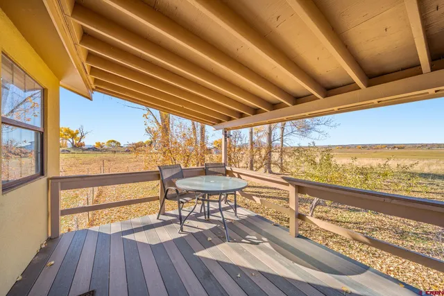 a view of a balcony with chairs and wooden floor
