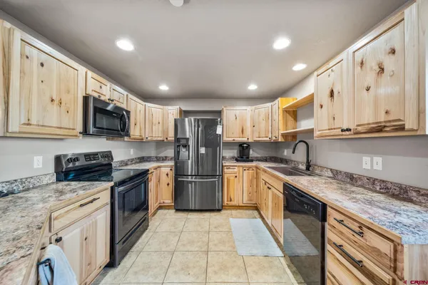a large kitchen with stainless steel appliances granite countertop a stove sink microwave and cabinets