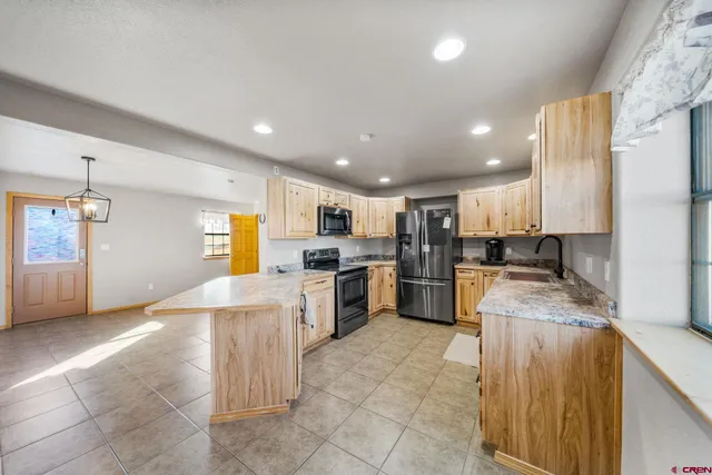 a large kitchen with a large counter top appliances and cabinets