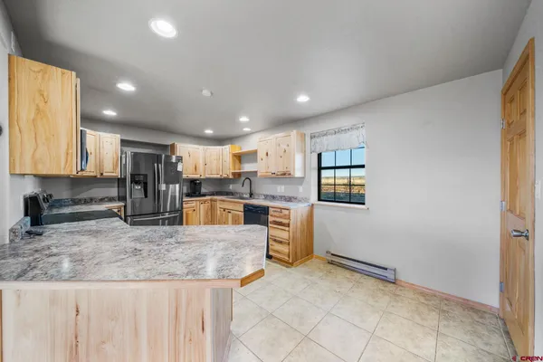 a kitchen with stainless steel appliances granite countertop a refrigerator and a stove top oven