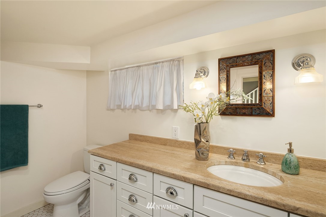 112 North 58th Street Seattle, WA 98103 - Photo 20 of 27 a bathroom with a granite countertop toilet sink and mirror