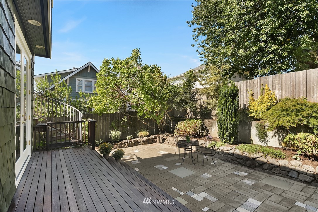 112 North 58th Street Seattle, WA 98103 - Photo 25 of 27 a view of a patio with table and chairs with wooden floor and fence