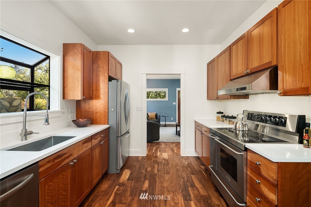 112 North 58th Street Seattle, WA 98103 - Photo 9 of 27 a kitchen with stainless steel appliances granite countertop a sink stove and refrigerator