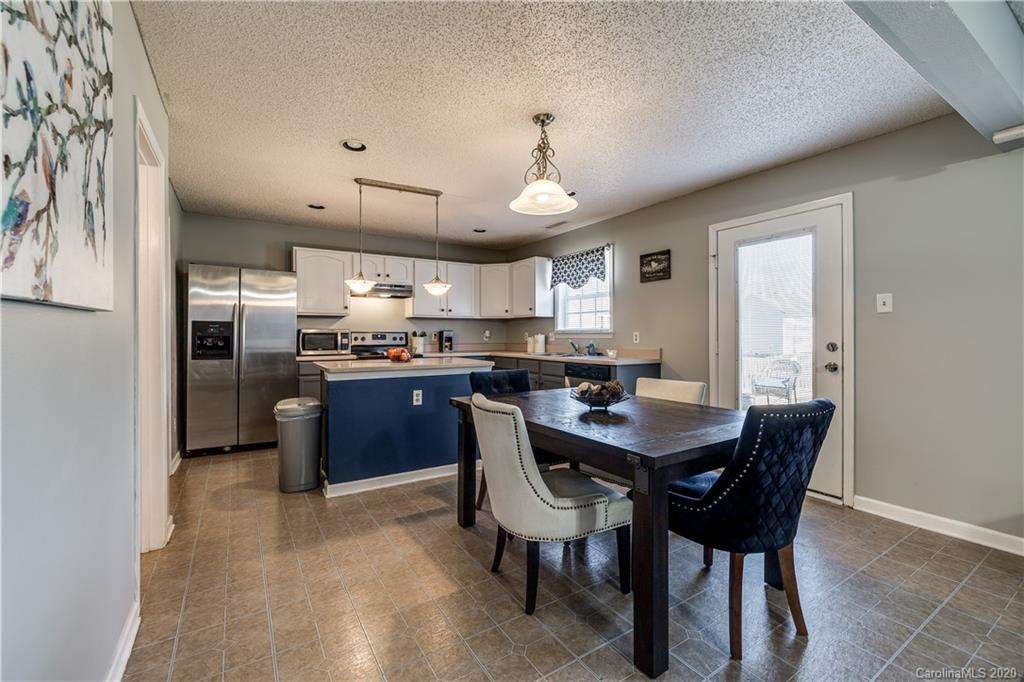 8808 Old Potters Road Charlotte, NC 28269 - Photo 11 of 34 a kitchen with refrigerator cabinets dining table and chairs